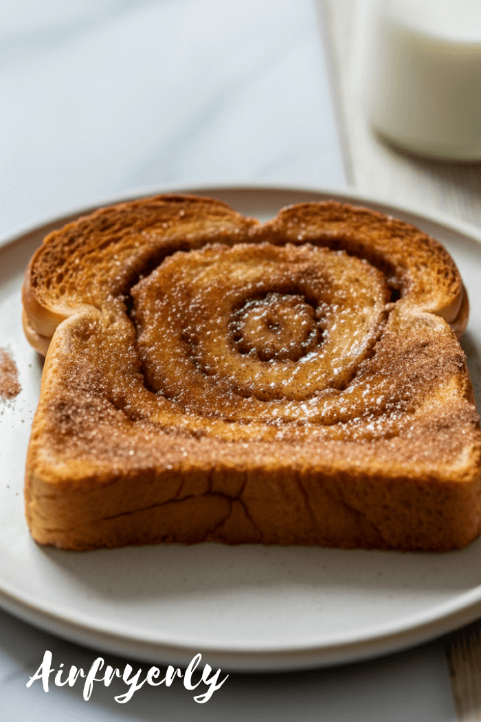 Golden, crispy air fryer cinnamon toast on a plate, topped with melted butter and cinnamon sugar, served for breakfast with coffee