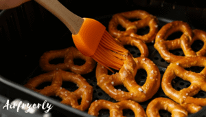 “Super Pretzels being brushed with melted butter and sprinkled with coarse salt before air frying.”