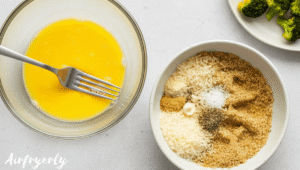 Beaten egg in a bowl and separate bowl with breadcrumb mixture including Parmesan and spices