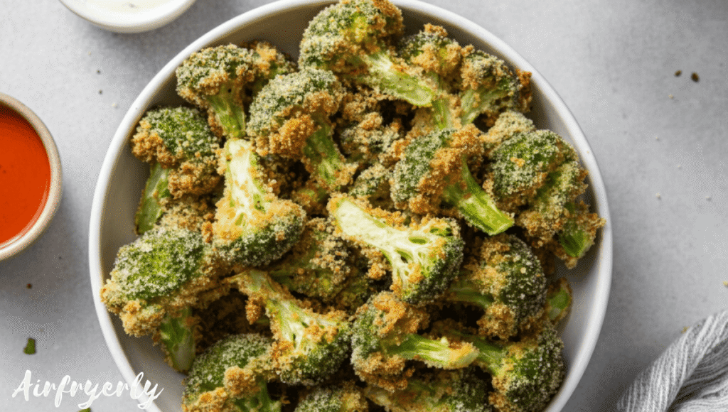 Golden-brown breaded broccoli florets served in a rustic bowl with dipping sauces on the side