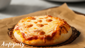Frozen mini cheese pizza placed in air fryer basket before cooking, with even spacing and no parchment, ready for air frying.