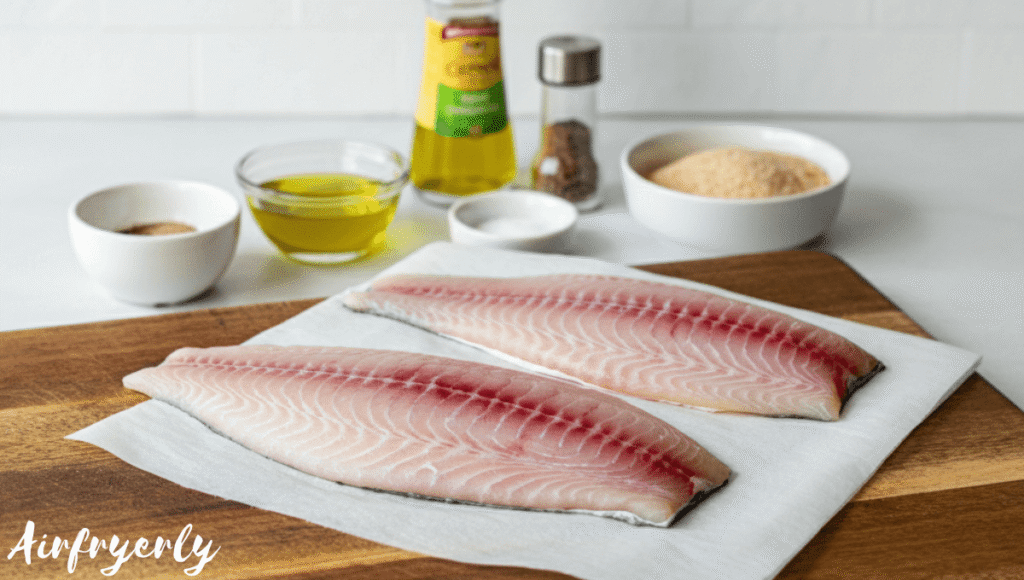 Seasoning grouper fillets with paprika, garlic powder, salt, and pepper