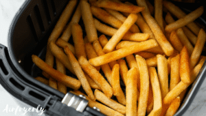 Frozen Checkers fries spread in a single layer inside the air fryer basket, ready to cook without thawing