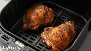 Jerk chicken thighs placed skin-side up in an air fryer basket, ready to cook at 380°F.