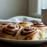 Golden brown frozen cinnamon rolls served on a white plate with icing drizzle, fresh from the air fryer – easy and quick breakfast idea