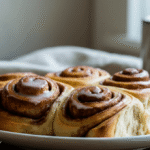Golden brown frozen cinnamon rolls served on a white plate with icing drizzle, fresh from the air fryer – easy and quick breakfast idea