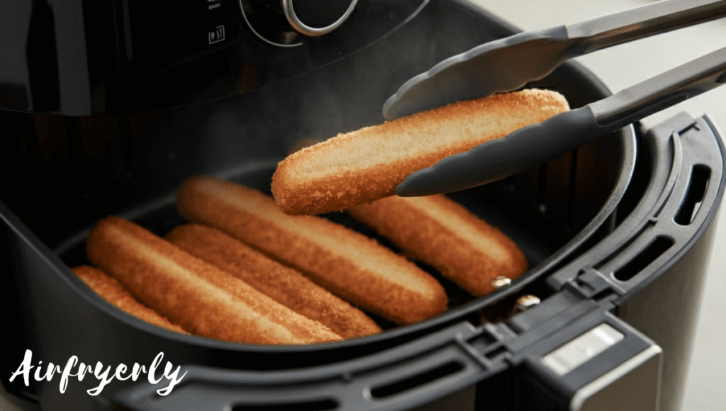 “Golden brown New York Bakery breadsticks halfway cooked in air fryer, being flipped with silicone tongs for even crisping.”