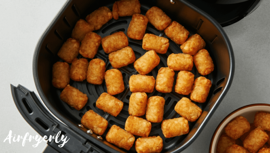 Halfway through cooking Ore Ida tater tots in air fryer with evenly browned edges

