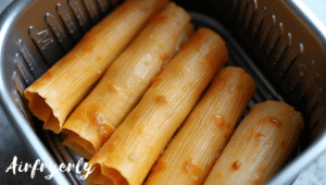 “Tamales arranged in a single layer inside air fryer basket”