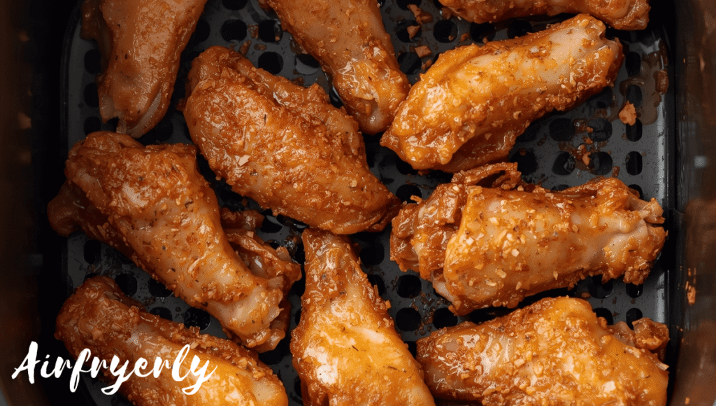 Frozen chicken wings in air fryer cooking until golden crispy with internal temperature reaching 165°F.